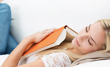 Woman relaxing at home with a book.