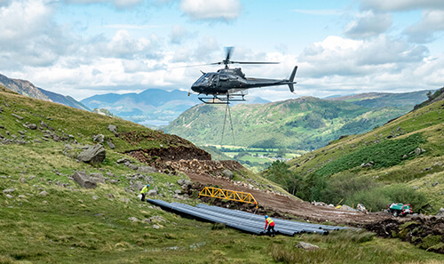 Helicopter delivering HDPE to Hydro Scheme in air