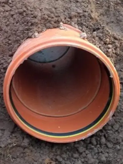 Underground drainage pipe installed in soil.