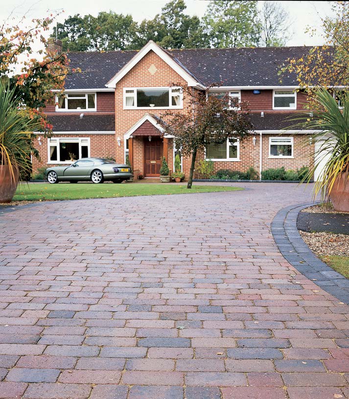 House with a brick-laid driveway.